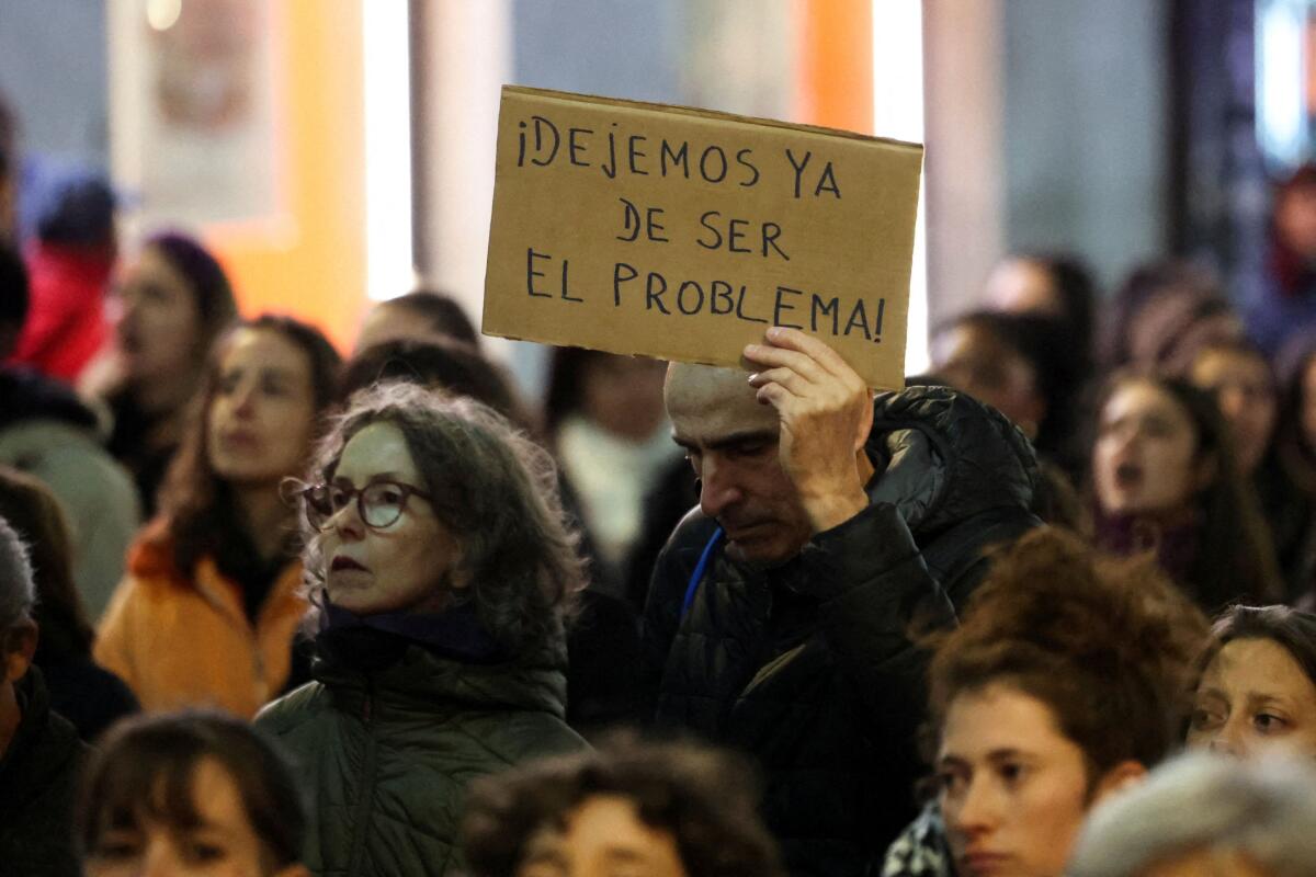 A man holds a placard reading "Let's stop being a problem now", as people attend a march to mark the International Day for the Elimination of Violence against Women, in Madrid, Spain, November 25, 2025.