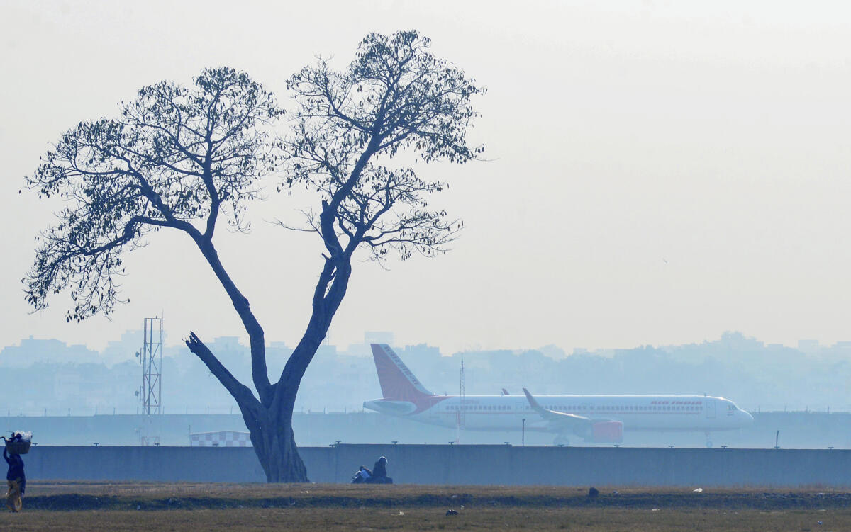 An airplane moves along the runway as dense fog reduces visibility at Birsa Munda Airport, in Ranchi