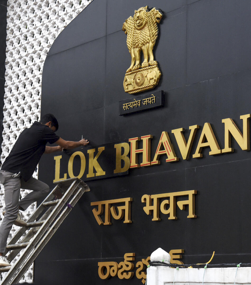 A worker installs lettering on a signboard reading 'Lok Bhavan', in Hyderabad, Tuesday, Dec. 2, 2025. The Union Home Ministry (MHA) wrote to all Governors and Lieutenant Governors suggesting that the name of 'Raj Bhavan' be changed to 'Lok Bhavan'