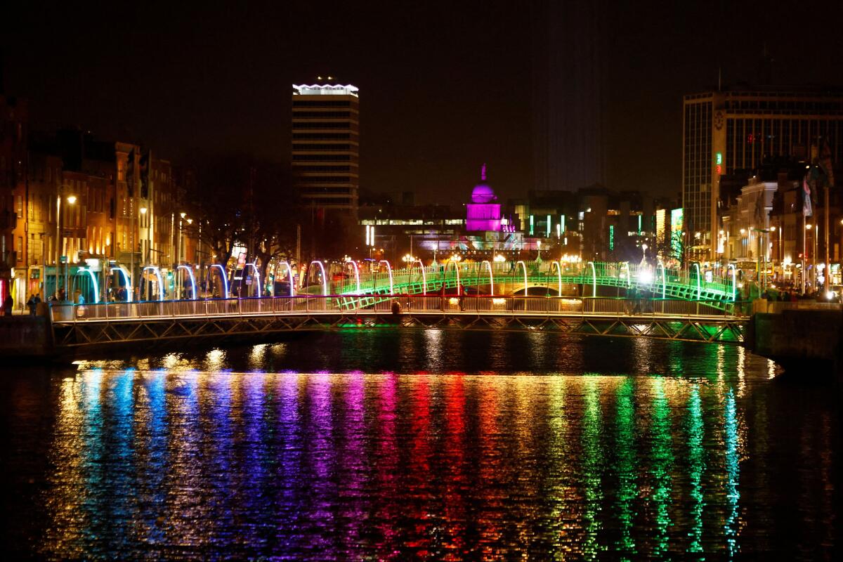 A winter lights Christmas installation reflect on the water in the River Liffey, in Dublin, Ireland