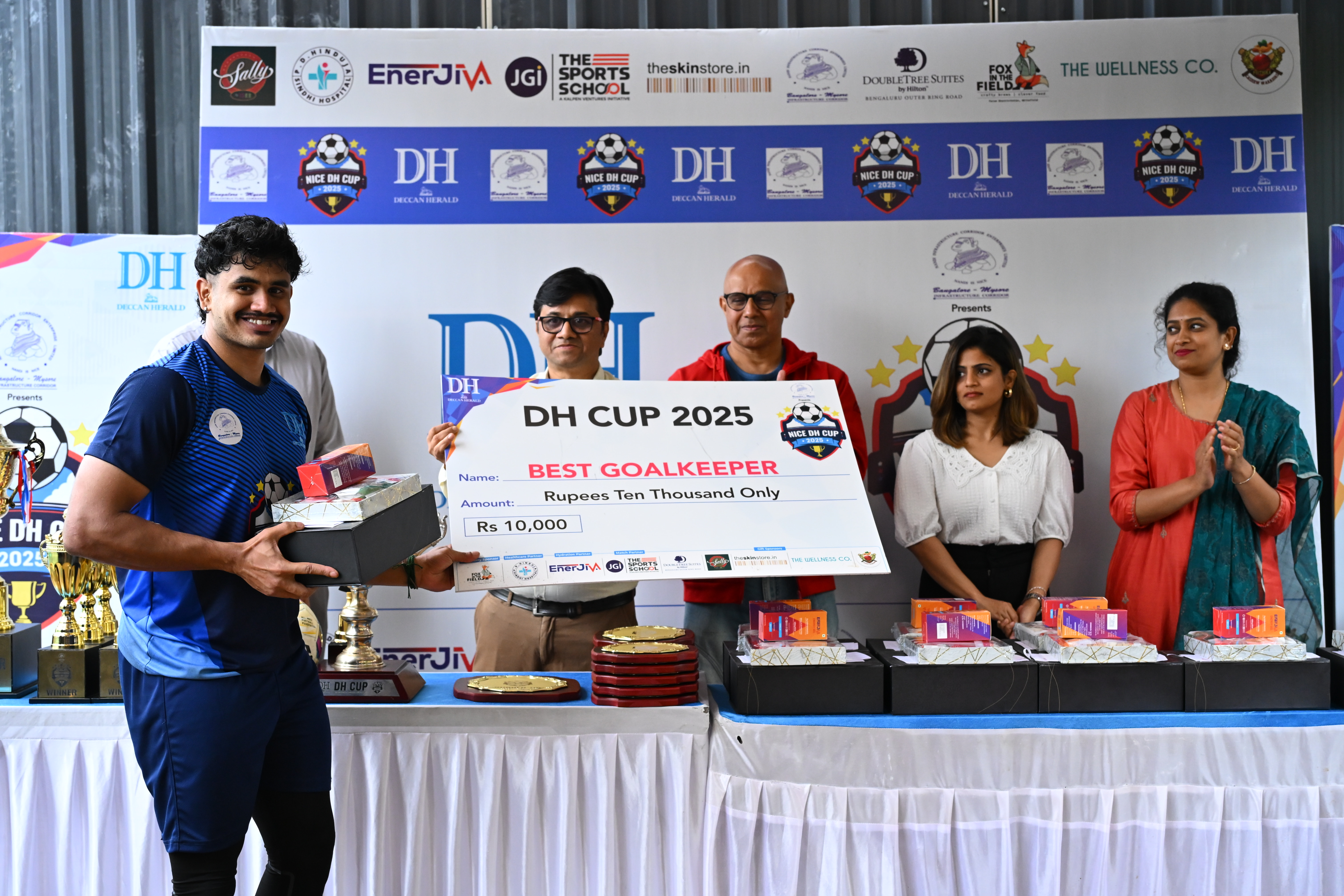 Suriya Kumaran R C team BOSCH receives the best goalkeeper award from Girish R Doddamani sports journalist Prajavani (center) and Dr Gul Mohamed Akbar marathoner and race director.