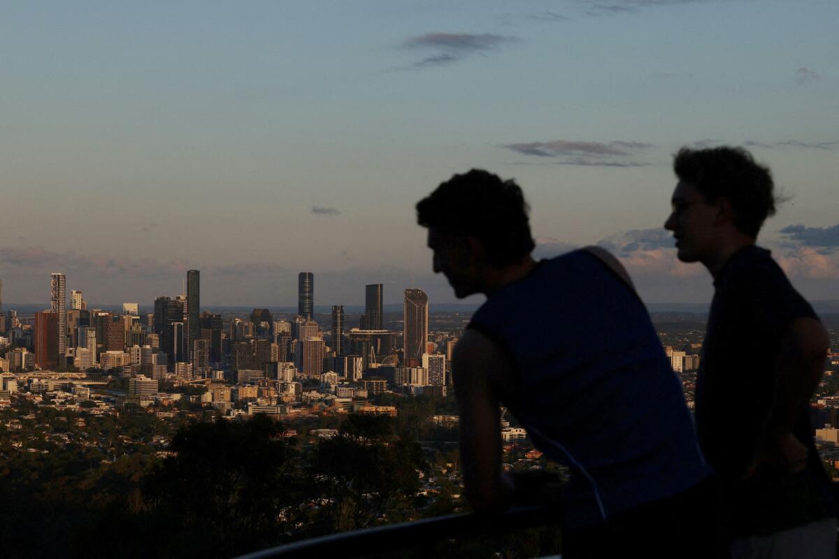 People look out towards the city skyline at sunset in Brisbane.