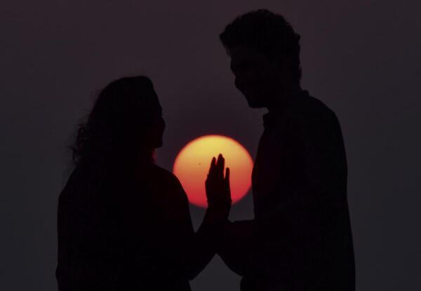 Visitors at a beach during sunset, in Kochi, Kerala.
