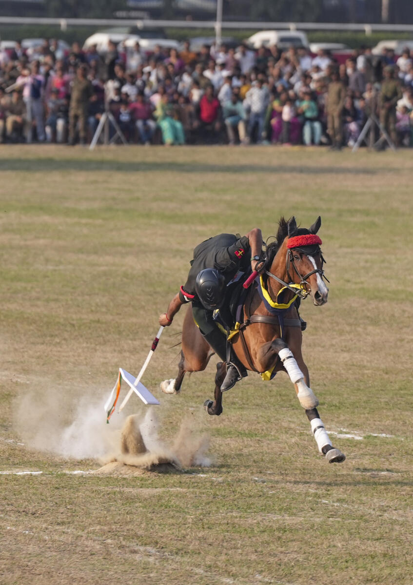 An army official rides a horse as part of 'Tent pegging' during an event organised to commemorate 'Vijay Diwas', in Kolkata.