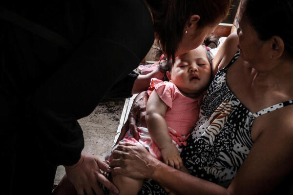 Marian Duhapa (31), kisses her 7-month-old daughter Quinn Dahlia Duhapa goodbye as she prepares to leave for Taiwan in search of work, in Irosin, Luzon Island, Philippines.
