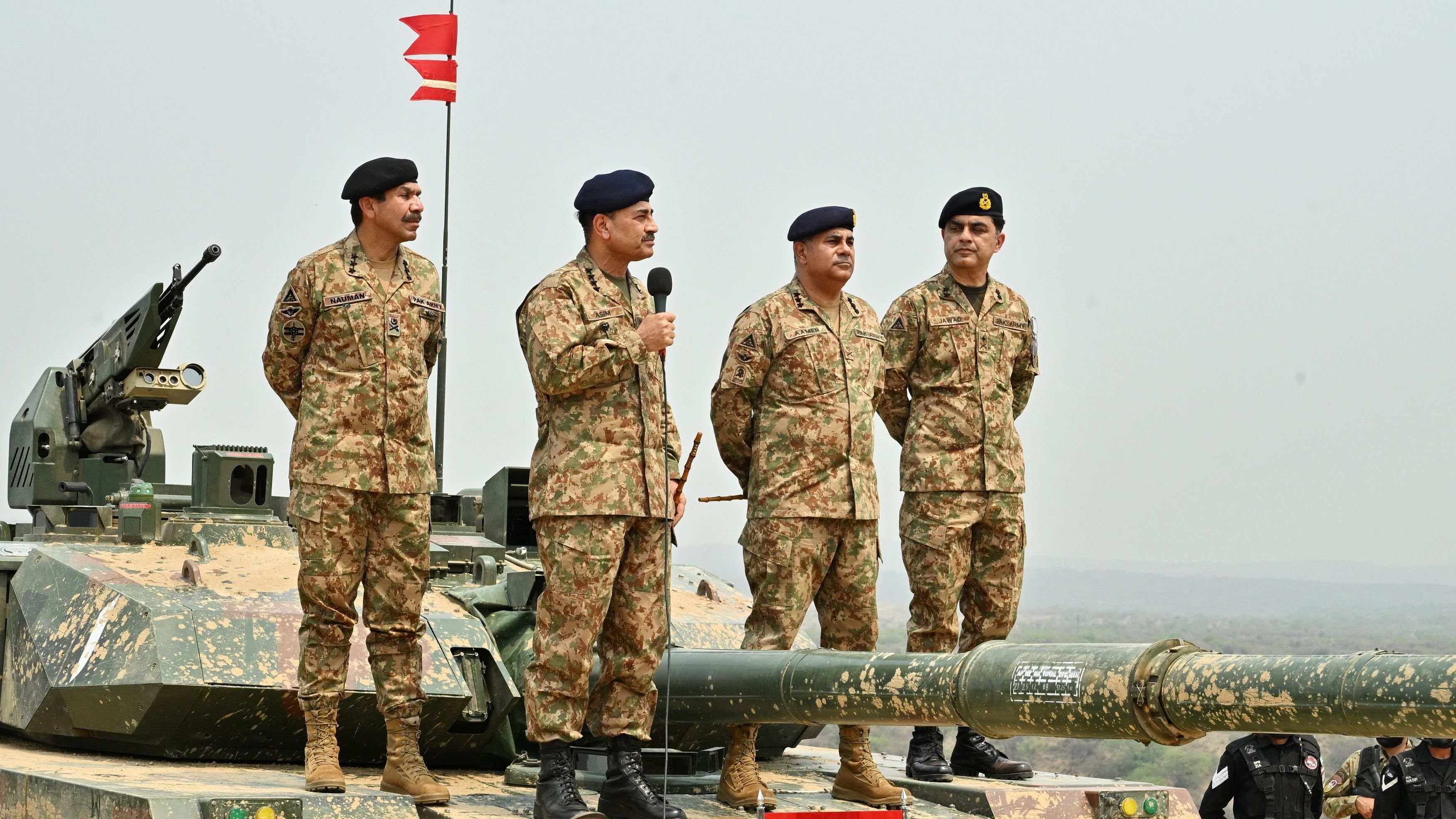 Chief of Army Staff of Pakistan Asim Munir holds a microphone during his visit at the Tilla Field Firing Ranges.