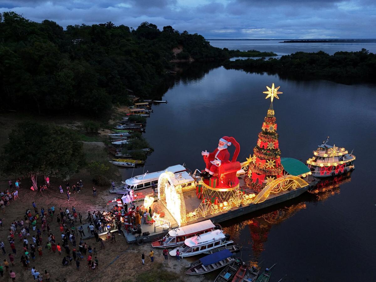A drone view shows a giant Santa Claus aboard a Christmas ferry, delivering holiday baskets and toys to the riverside community of Bela Vista do Jaraqui during the 'Natal das Aguas' event organized by the Manaus city hall at the banks of Rio Negro in Manaus, Amazonas state, Brazil.