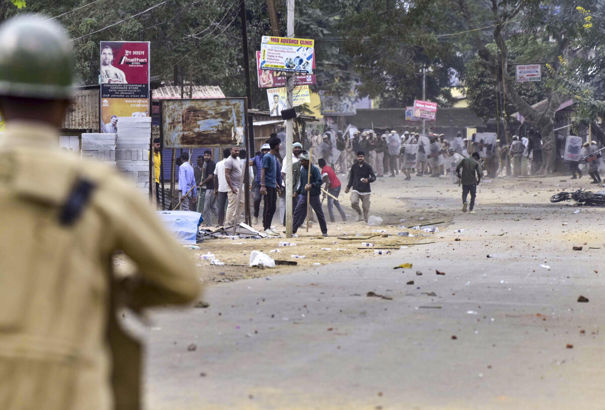 People throw stones during a clash between two groups over the issue of eviction, at Kheroni in West Karbi Anglong district, Assam.