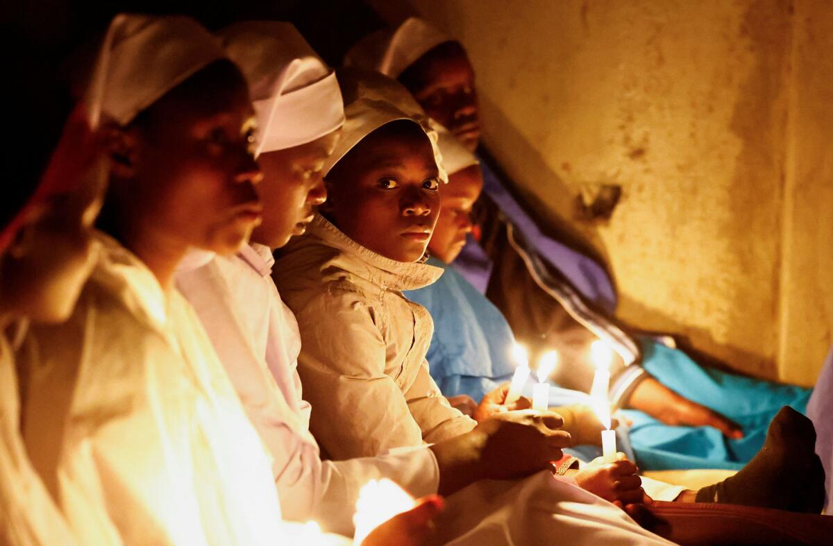 Christian faithful of the Legio Maria African Mission church hold candles as they attend a Christmas eve vigil mass in their church in the Fort Jesus area of Nairobi, Kenya.