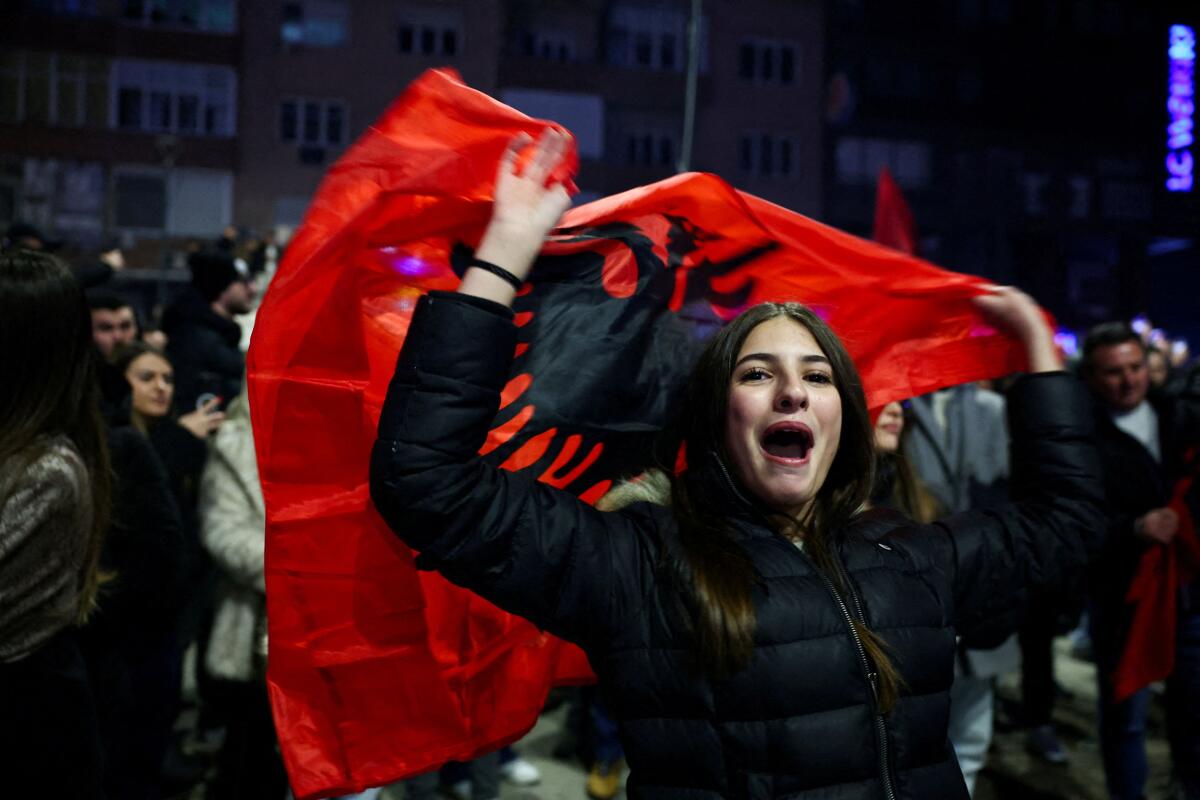 A woman holds an Albanian flag while supporters of Levizja Vetevendosje (Movement for Self-Determination) party celebrate, as the party won more than half of the votes in a snap parliamentary election, nearly a year after a political deadlock that prevented the formation of a new government, in Pristina, Kosovo, December 28, 2025.