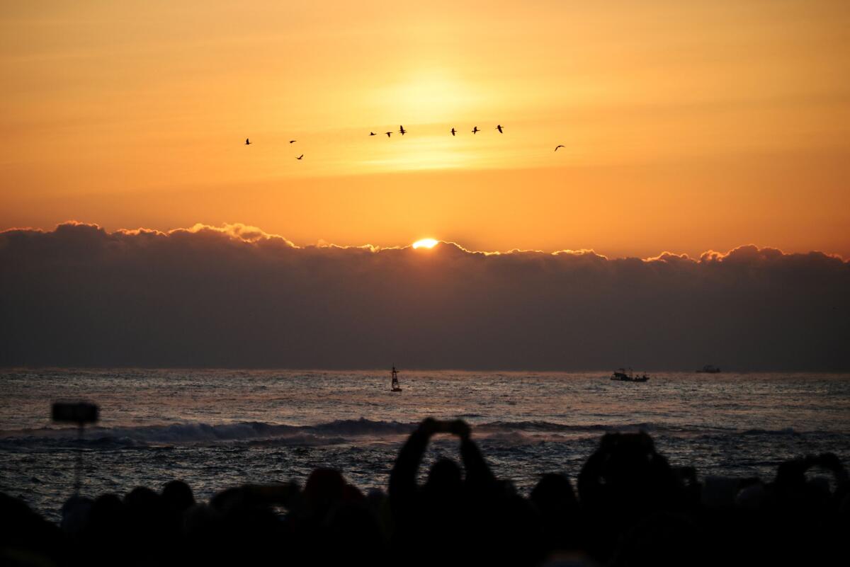 People look at the first sunrise of the year at Sokcho beach in Sokcho, South Korea, January 1, 2026.