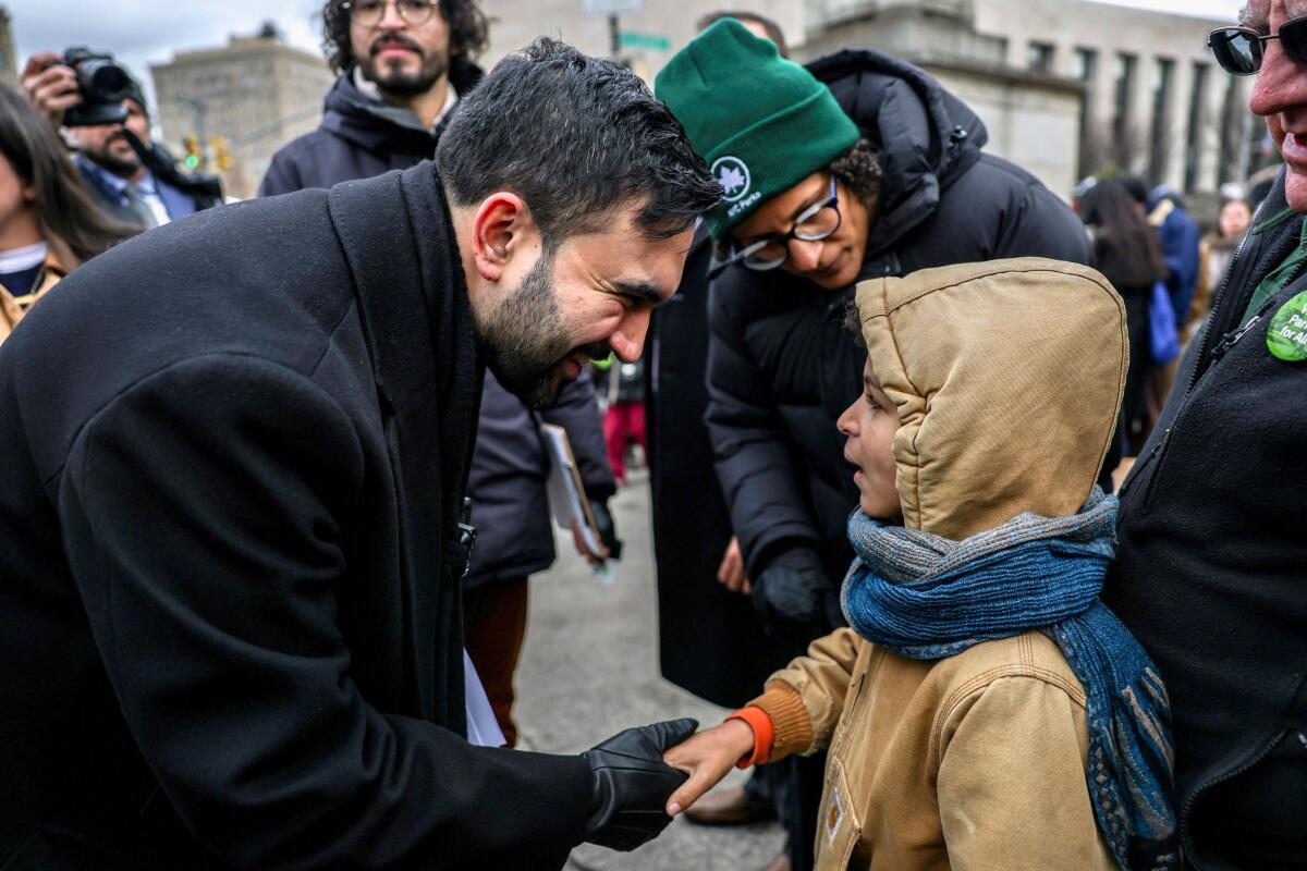 New York City Mayor Zohran Mamdani greets a child after a press conference at Grand Army Plaza in the Brooklyn borough of New York City, U.S., January 2, 2026.