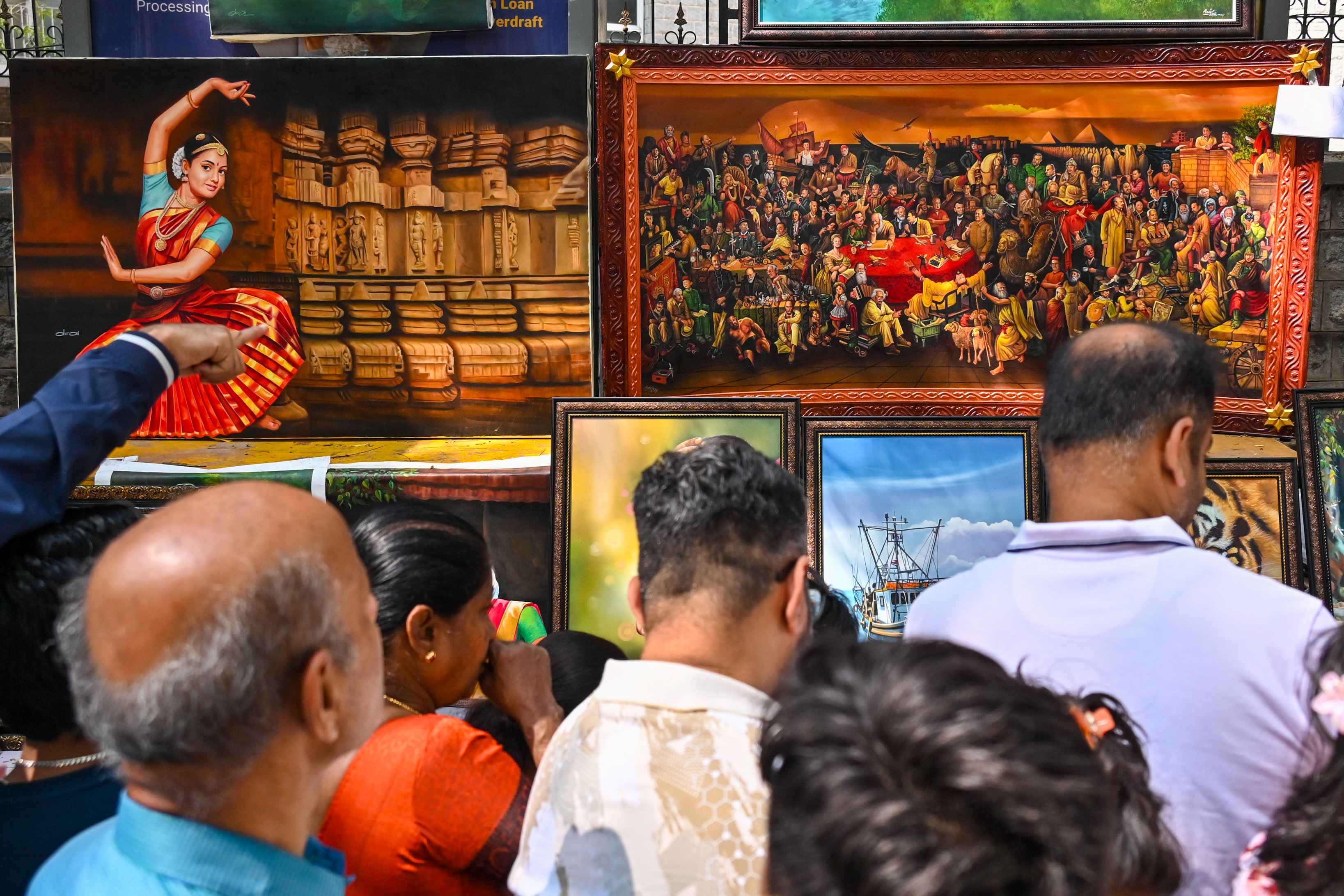 Enthusiasts browse through paintings on sale at the Chitra Santhe art fair on Kumara Krupa Road in Bengaluru on Sunday. DH PHOTOs/PUSHKAR V