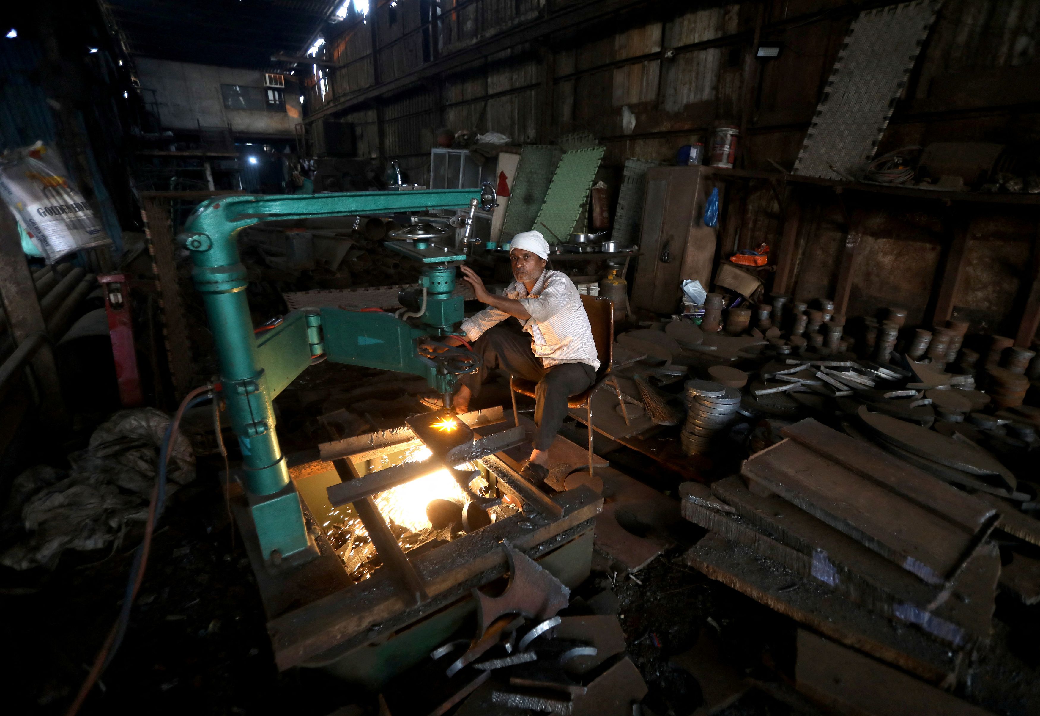 FILE PHOTO: A worker operates a machine inside a small scale manufacturing unit in Mumbai India February 1 2023. REUTERS/Niharika Kulkarni/File Photo