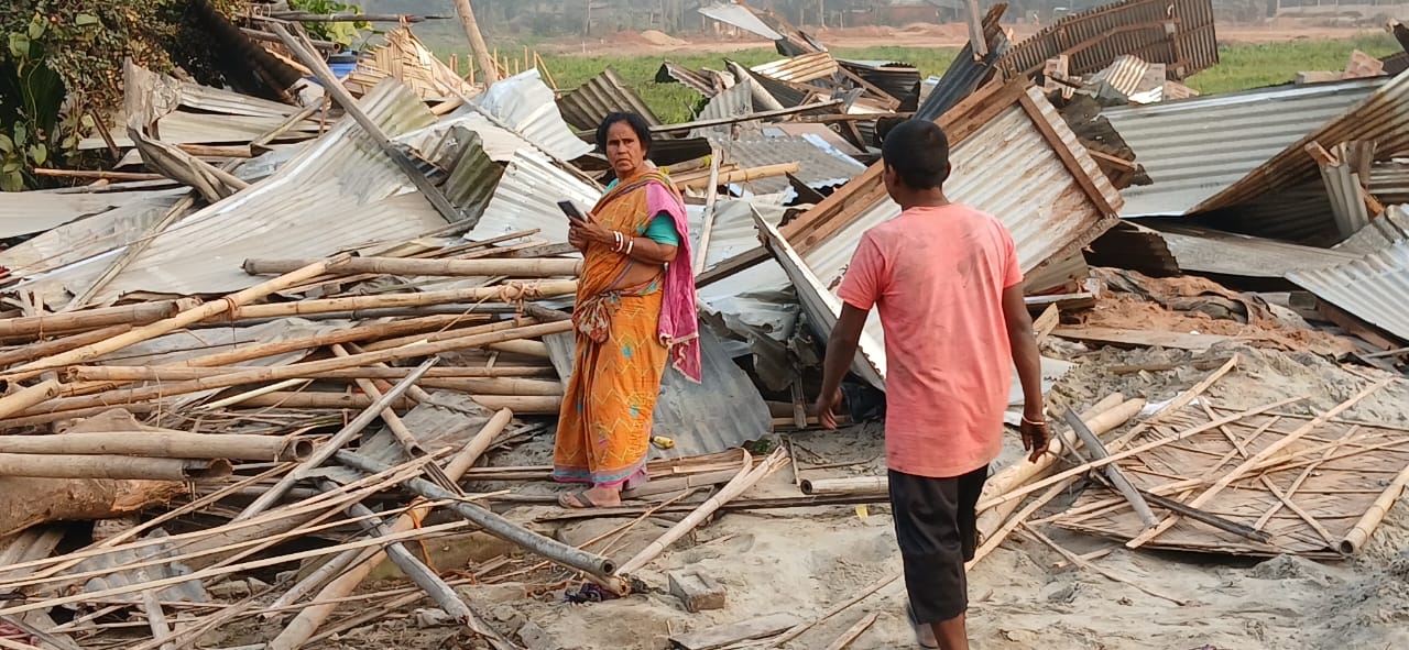 A woman checks for items amid the demolished houses.