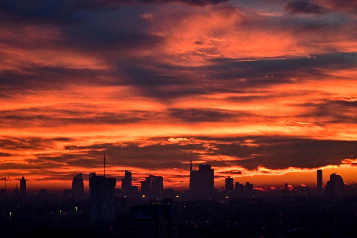 The Milan skyline at sunset with clouds illuminated over the city, in Milan, Italy