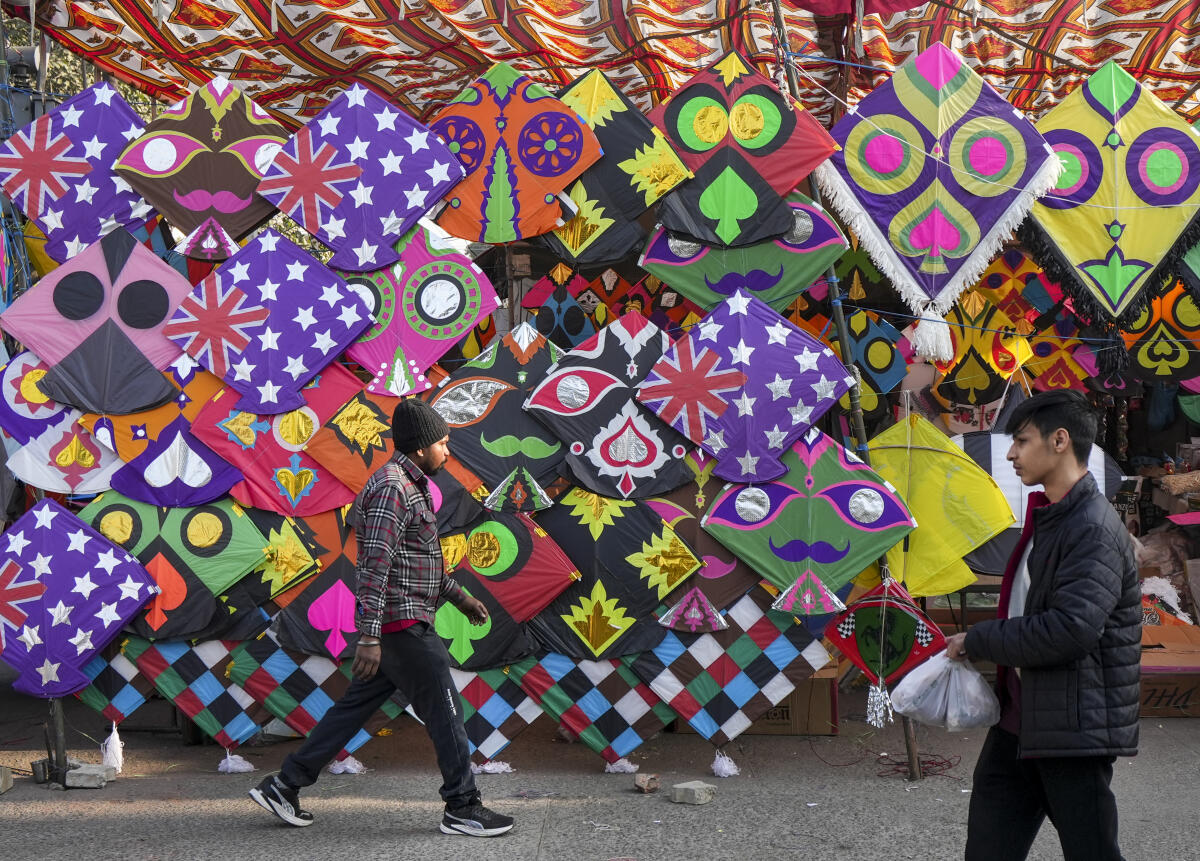 A man walks past kites at a stall on the eve of the ‘Lohri’ festival, in Amritsar