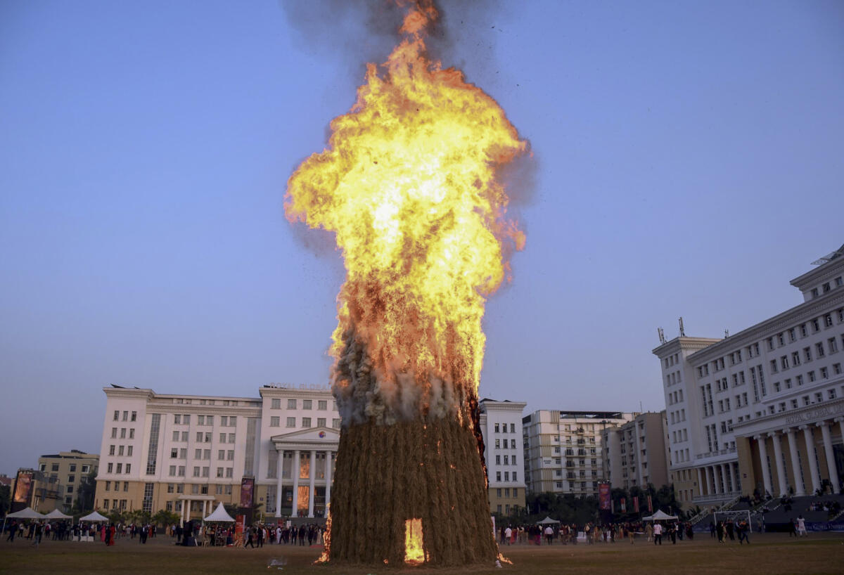 Flames billow out from a ‘Meji’, also known as ‘Bhelaghar’, temporary huts made from bamboo, straw, and dry leaves, as part of ‘Magh Bihu’ festival celebrations, in Guwahati
