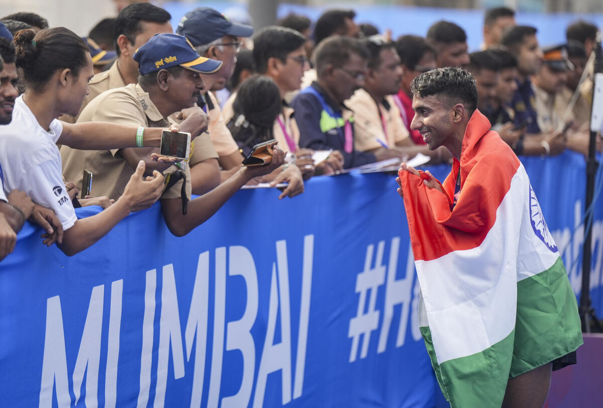 Indian Elite Men's race winner Kartik Karkera greets the gathering during the 21st edition of the Tata Mumbai Marathon, a World Athletics Gold Label Race, on the illuminated Bandra-Worli Sea Link, in Mumbai. 