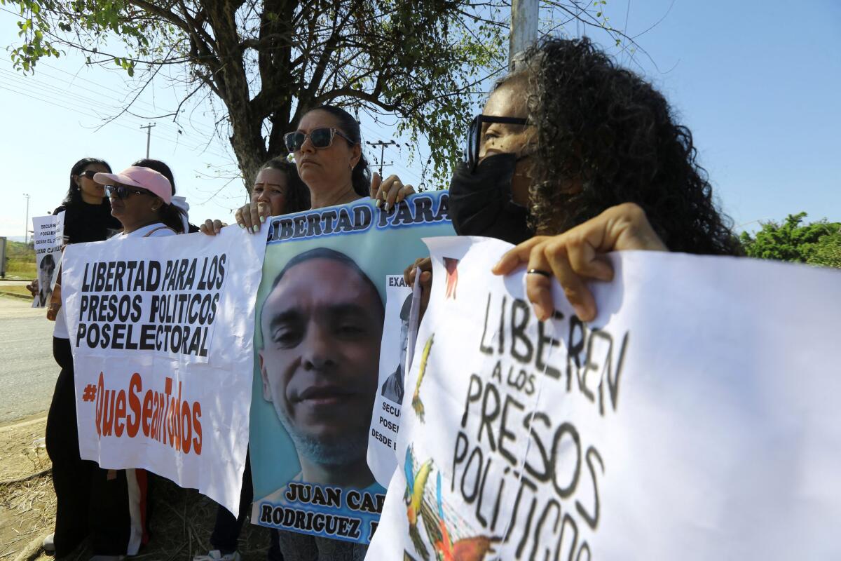 Family members hold signs during a protest for the release of their loved ones outside the Centro de Formacion para el Hombre Nuevo “El Libertador” prison complex, amid prisoner releases by the Venezuelan government following the U.S. capture of Nicolas Maduro, in Tocuyito, Venezuela. Credit: Reuters