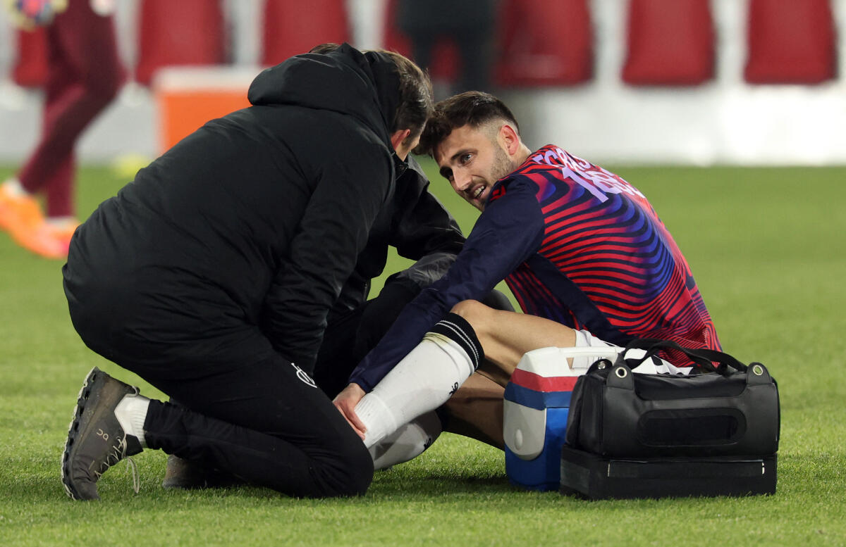 Basel's Dominik Schmid receives medical attention after sustaining an injury during the warm up before the match. Reuters