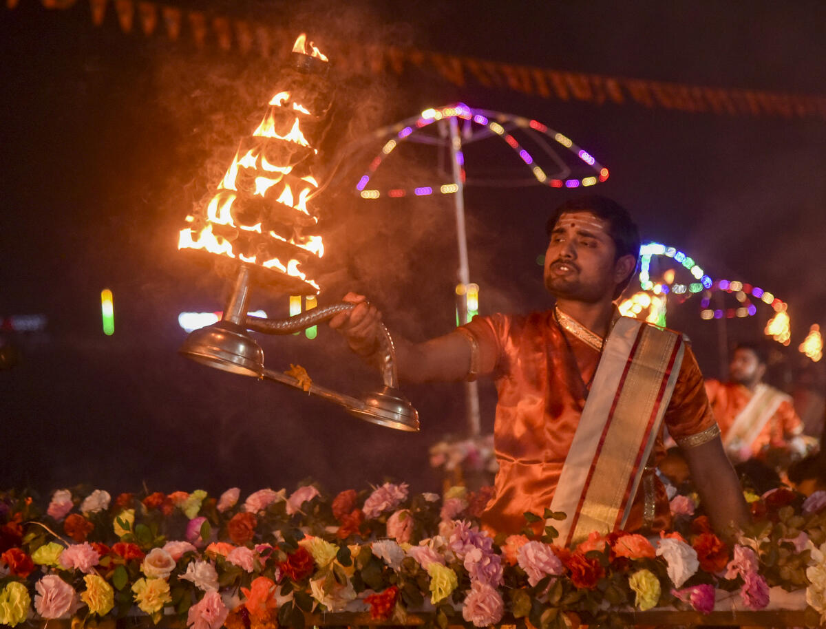 A priest performs 'aarti' during the second anniversary of the Ram Mandir Pran Pratishtha Diwas, at Atreyee riverbanks in Balurghat, West Bengal. PTI