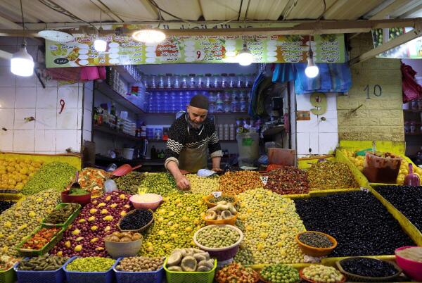 A shop owner sorts olives at his stand at a neighbourhood market in Casablanca, Morocco.