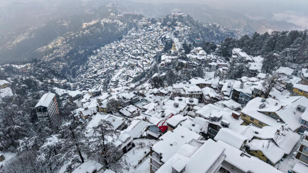 An aerial view of snow-covered houses and hills after fresh snowfall, in Shimla.
