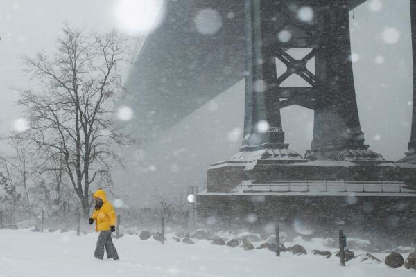A person walks amid a major winter storm spreading across a large swath of the United States, in Brooklyn, New York City, US.