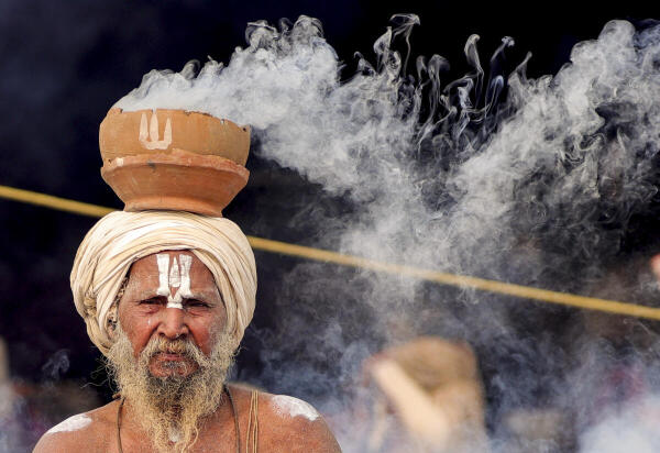 A 'sadhu' performs rituals during the ongoing 'Magh Mela' festival, in Prayagraj.