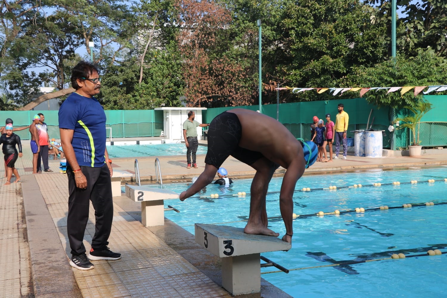 Swimming coach Umesh Kalghatgi instructs a physically challenged boy. 