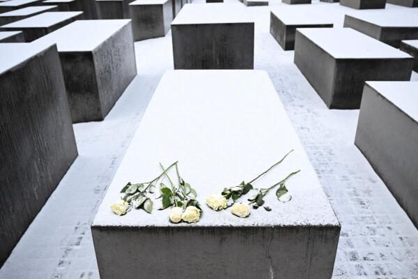Flowers lies on a snow-covered concrete stele of the Memorial to the Murdered Jews of Europe on the International Holocaust Remembrance Day, in Berlin, Germany.