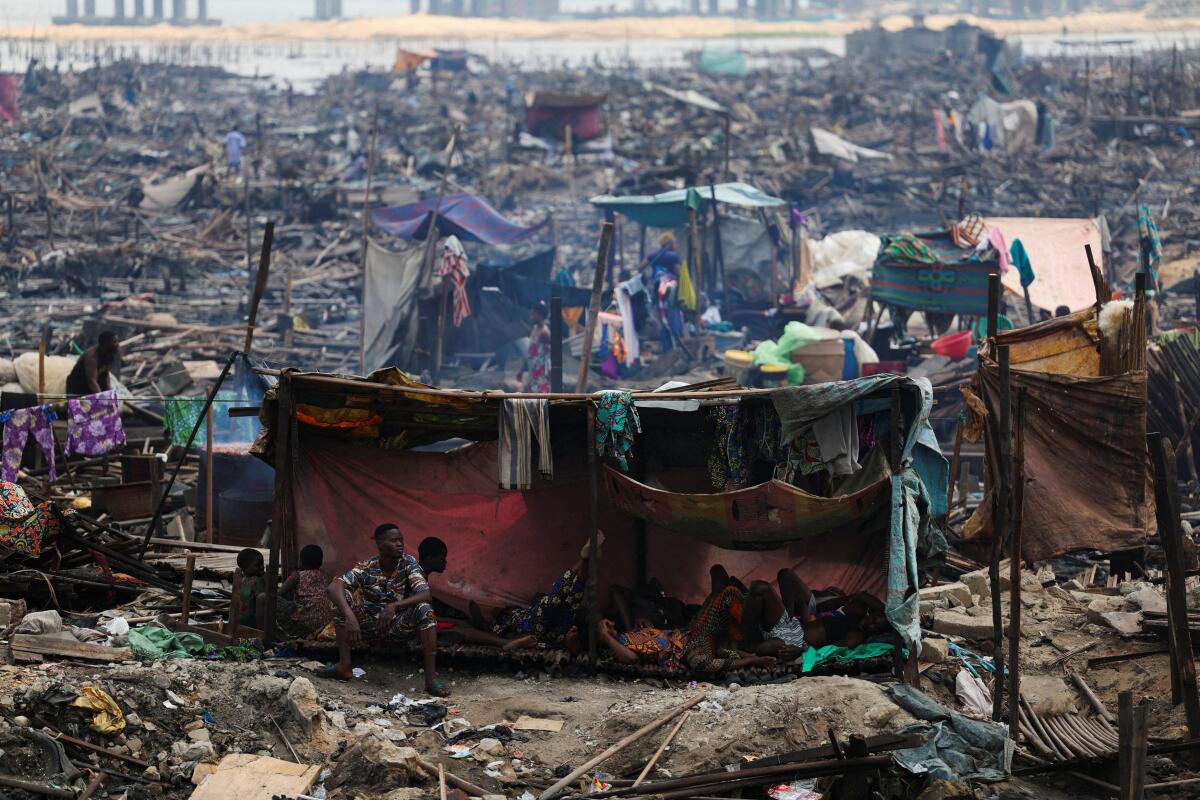 People rest inside a makeshift shelter as authorities burn remaining structures in the Makoko riverine community in Lagos, Nigeria, January 25, 2026. Officials are removing structures, including homes and schools, near power lines, in a wider push to recover lagoon-side land from the historic fishing community often called the "Venice of Nigeria."