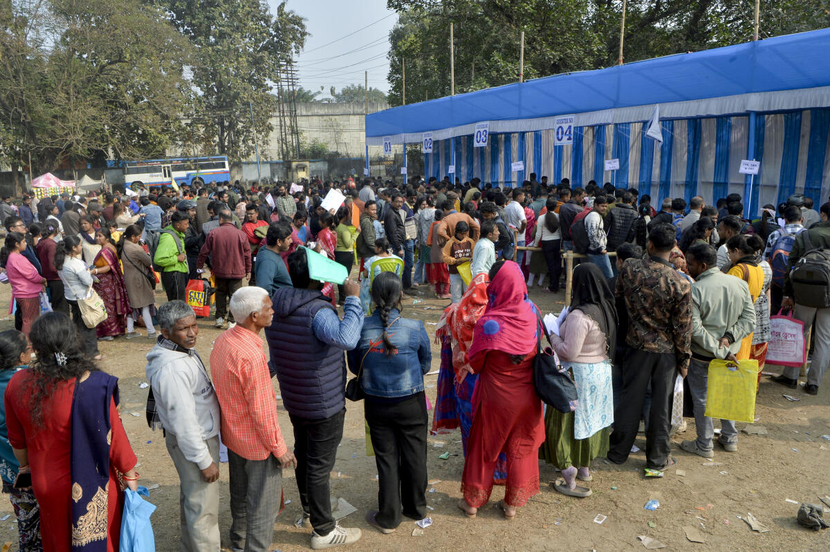 People stand in long queues for document verification at a hearing centre under the Special Intensive Revision (SIR) of electoral rolls, on the outskirts of Siliguri, West Bengal.