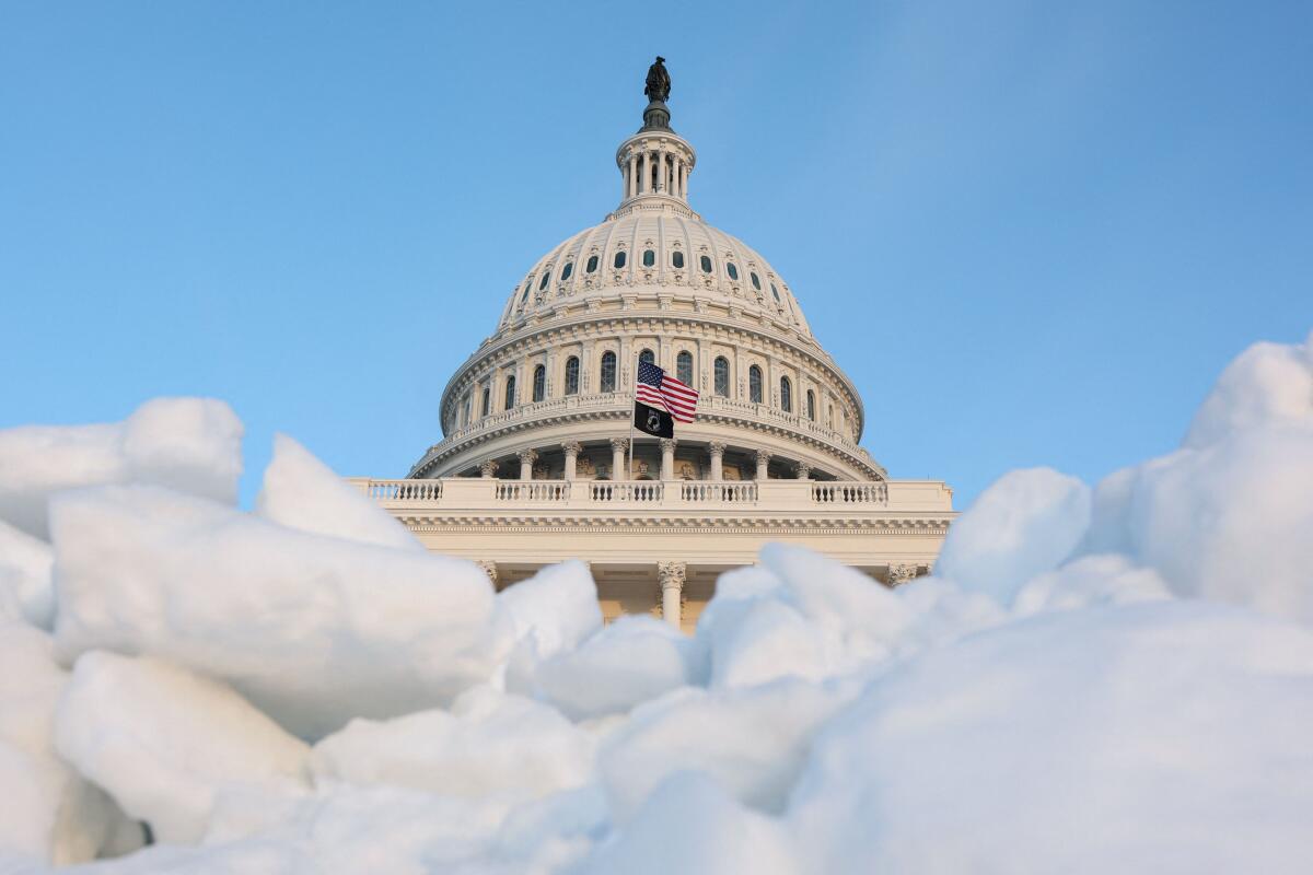 The sun sets on the U.S. Capitol building near a pile of snow and ice, as members of Congress work to resolve a dispute over immigration enforcement and avert a looming partial government shutdown, on Capitol Hill in Washington, D.C.