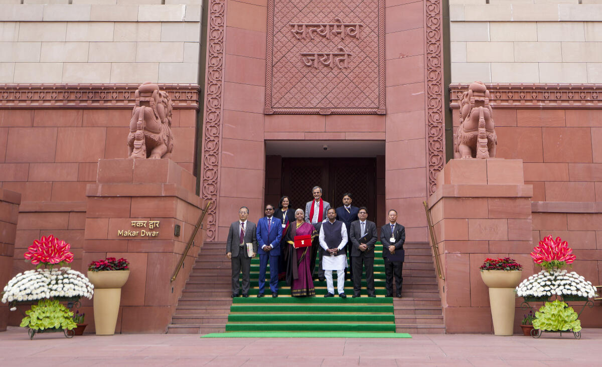 Finance Minister Nirmala Sitharaman shows the digital tablet, enclosed in a traditional red 'bahi-khata' style pouch, at the Parliament premises before the presentation of the ‘Union Budget 2026-27’, in New Delhi.