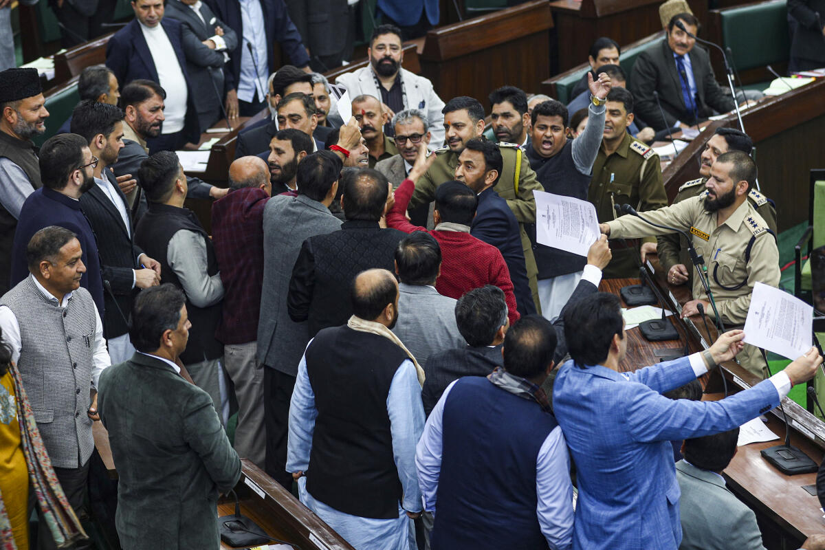 Marshals attempt to calm the agitated MLAs during an uproar, at the Budget session of the Jammu and Kashmir Legislative Assembly, in Jammu.
