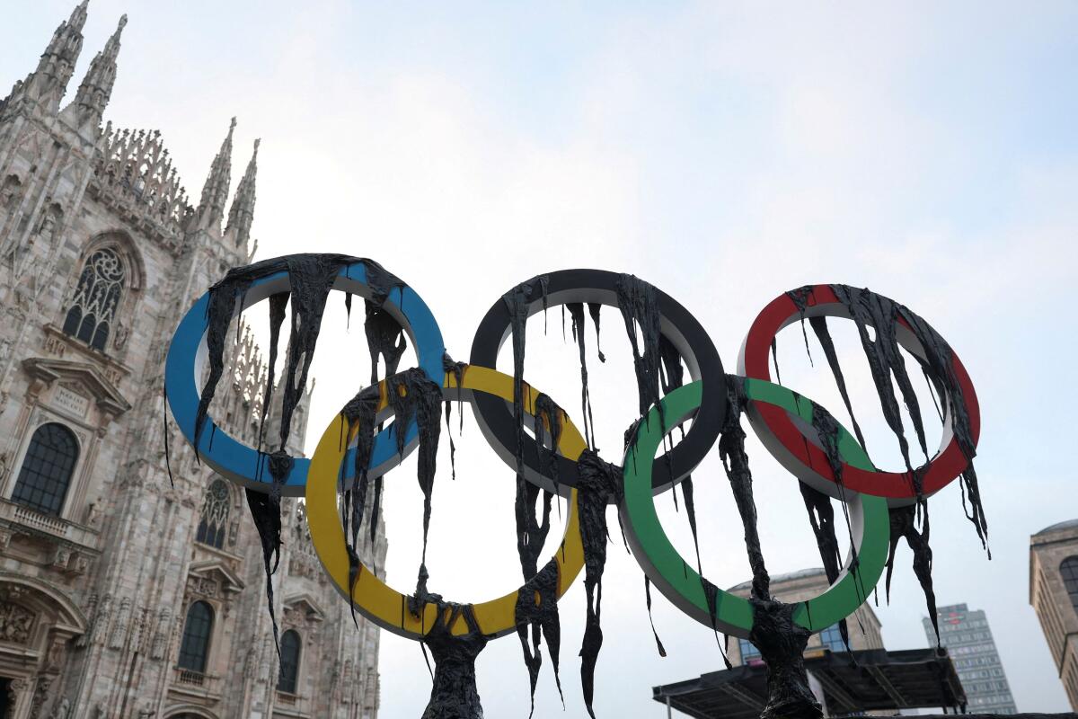 Environmental activists from Greenpeace unveil a large symbolic installation during a demonstration near the Duomo di Milano, as the Olympic torch arrives in Milan, Italy.