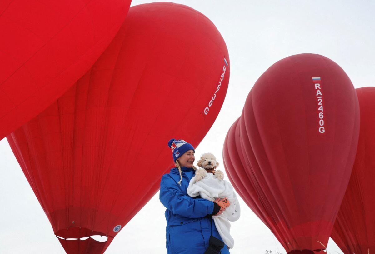 A participant holds a dog during the "Festival of Hearts 2026" hot air ballooning event, organized by the Aerowaltz aeronautic club, in the Moscow region, Russia, February 7, 2026.