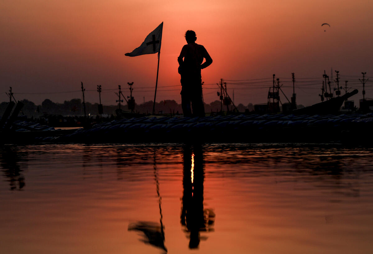 A man stands on a boat at sunset during the ongoing Magh Mela at the Sangam, in Prayagraj, Saturday, Feb. 7, 2026.