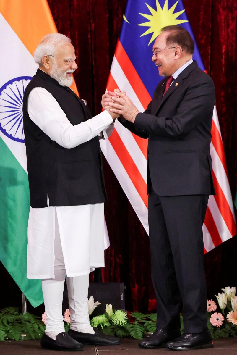 Prime Minister Narendra Modi and Malaysian Prime Minister Anwar Ibrahim hold hands during a press conference on the second day of Modi’s official visit, in Putrajaya, Malaysia.