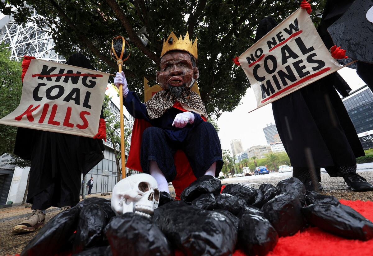 Members of Extinction Rebellion stage a protest with a figure depicting South African Minister of Mineral and Petroleum Resources, Gwede Mantashe, to highlight the need for South Africa and other countries to move away from coal production and honour their climate commitments, outside the Investing in African Mining Indaba conference in Cape Town, South Africa, February 9, 2026.