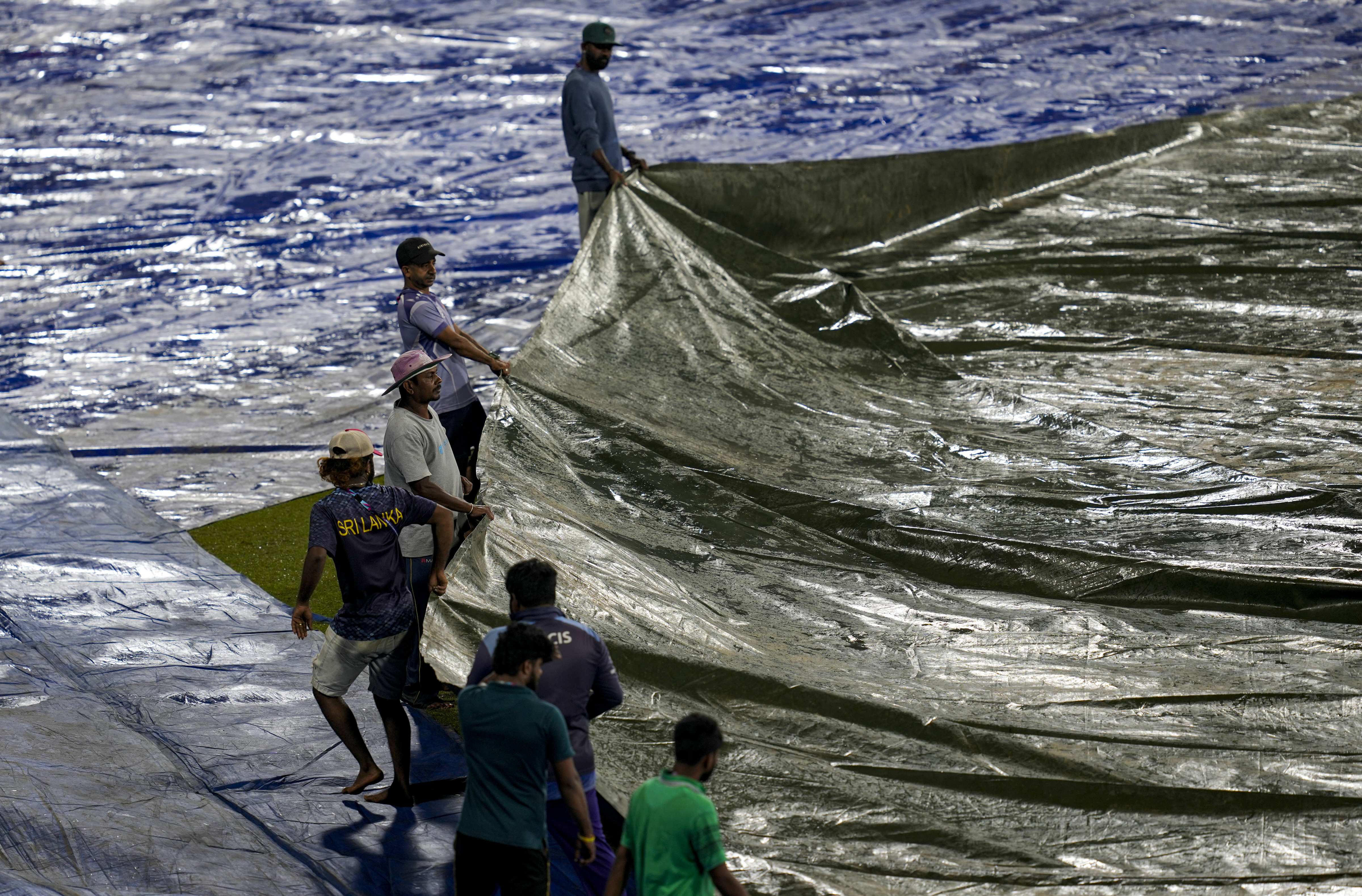 Ground staff cover the ground ahead of the ICC Men's T20 World Cup 2026 match between India and Pakistan at the R Premadasa Stadium, in Colombo