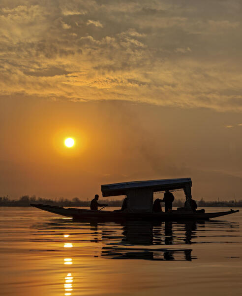 Tourists enjoy a shikara ride during sunset in Dal Lake, in Srinagar.