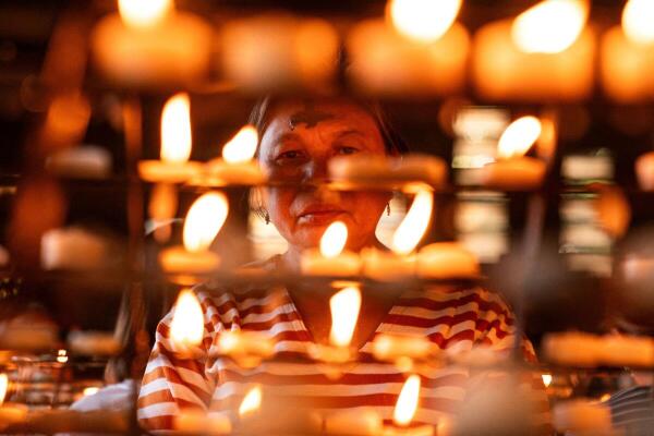 A woman with an ash cross on her forehead prays after an Ash Wednesday Mass, at Baclaran Church in Paranaque, Metro Manila, Philippines.