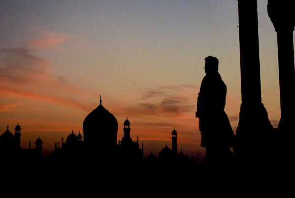 A man stands near the Taj Mahal at sunset, in Agra.