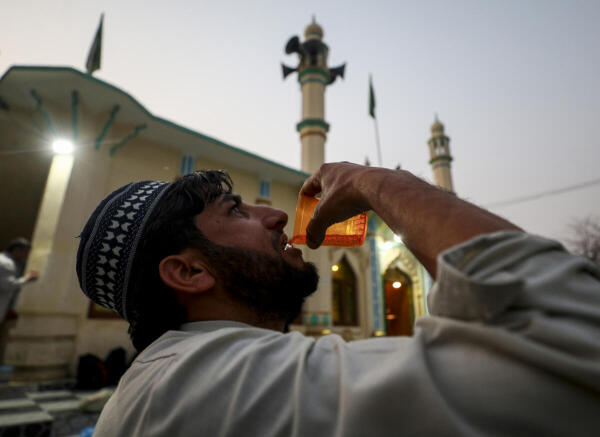 A man drinks water as he breaks his fast during 'Iftar' in the holy month of 'Ramzan' in Jammu.