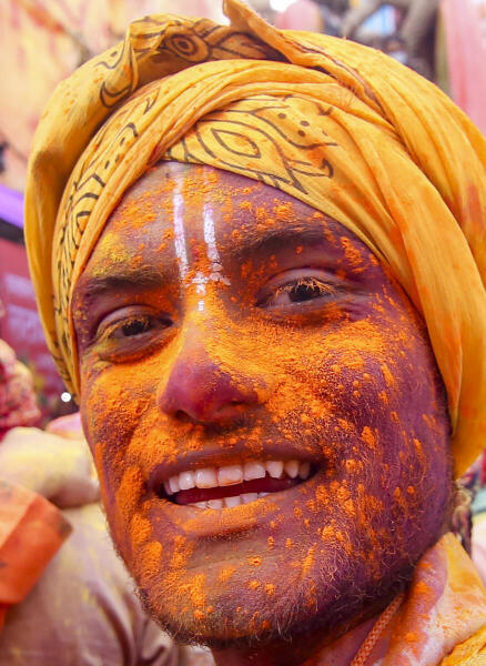 A man daubed in colours during the Lathmar Holi festival celebrations, in Barsana, Mathura.