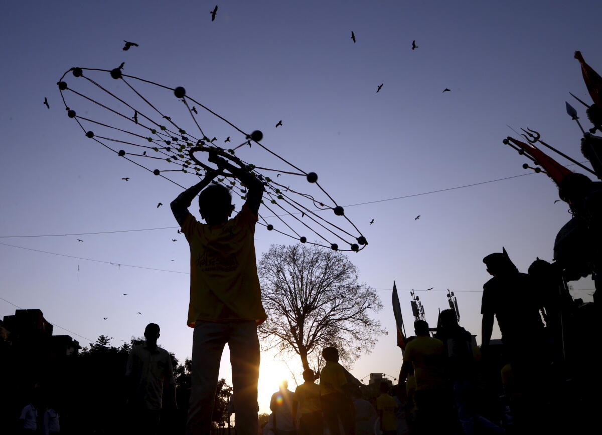 A participant performs with a traditional circular acrobatic prop during the 'Nagar Devi Yatra' of Goddess Bhadra Kali on Ahmedabad Foundation Day, in Ahmedabad, Gujarat.