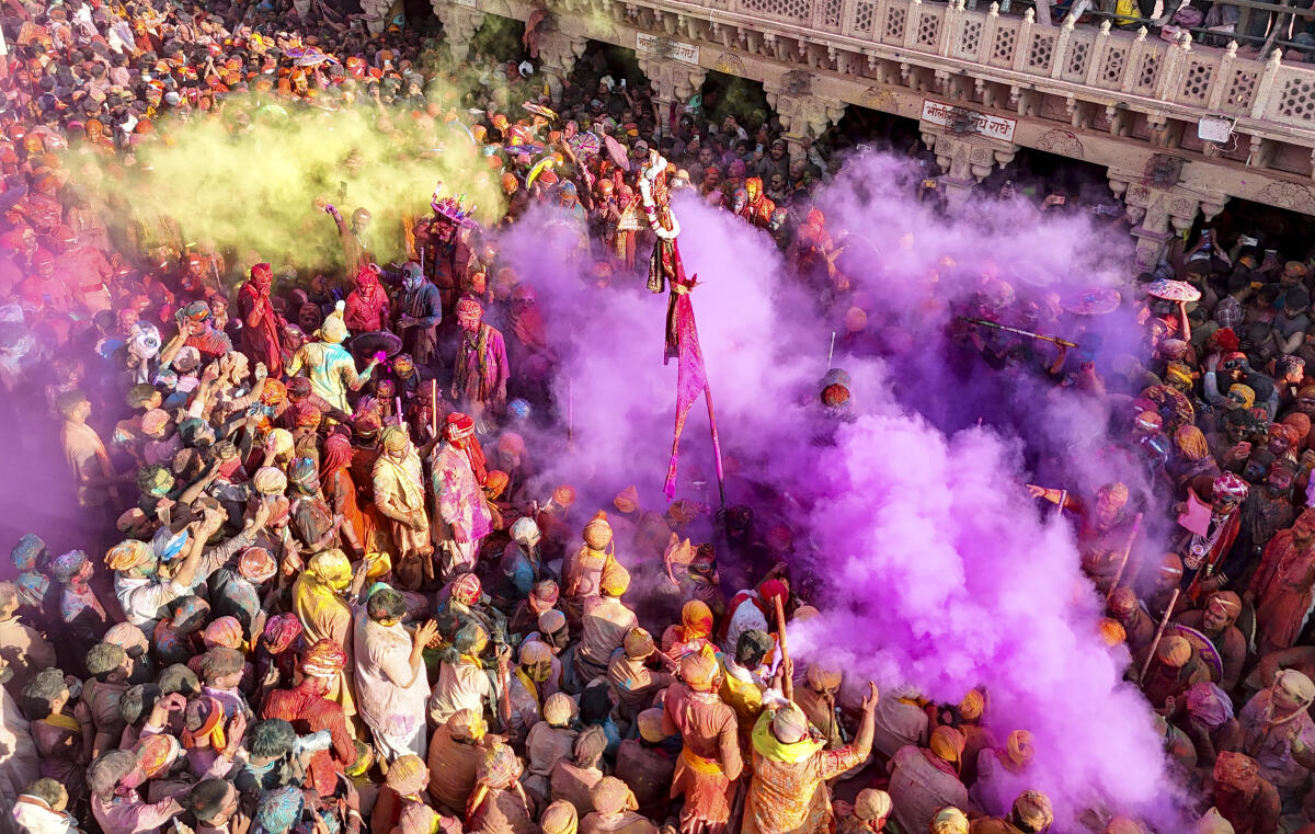 People celebrate amid ‘Holi’ festivities, near Shri Nand Baba Temple, in Nandgaon, Mathura.